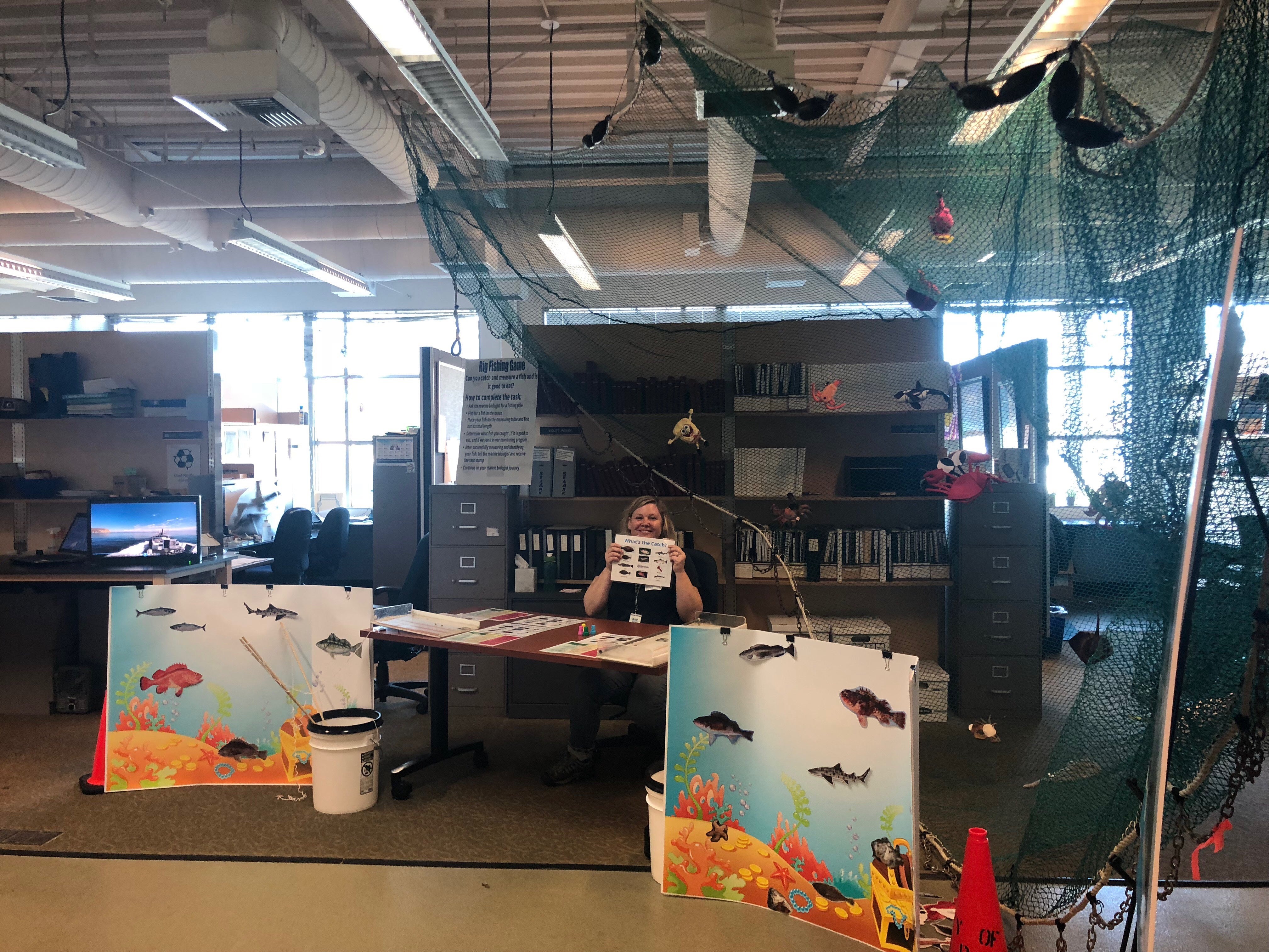 A marine biologist sits at a outreach station about trawl community sampling as part of the City's Ocean Monitoring Program.