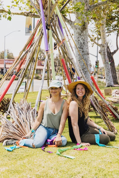 Kasi Muñoz and Kline Swonger sitting next to their art installation