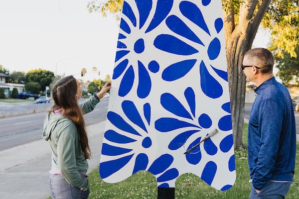 Park visitors looking at a popsicle-shaped art sculpture